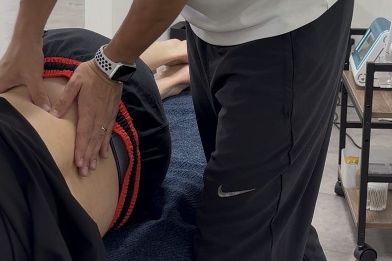 帯広のATHBASE整体院で腰部の状態を確認しながら施術する理学療法士