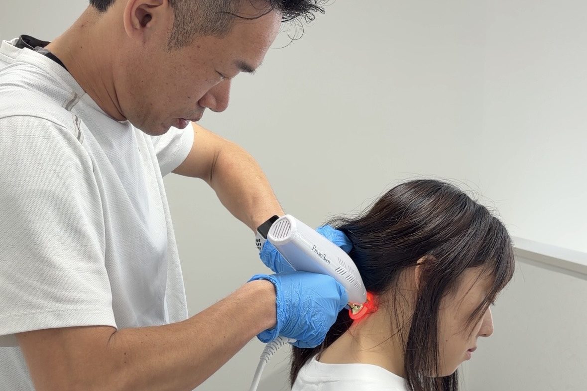 帯広のATHBASE整体院で女性の首・肩にフィジオショットを行う理学療法士